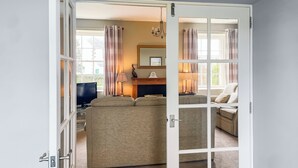 A room with a large bed, a television, and a fireplace. - Six the Square - UK48869 (Belford)