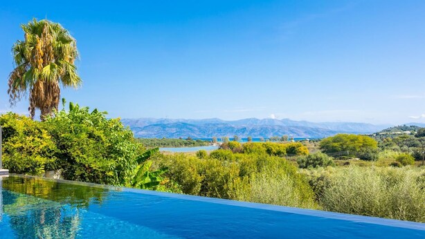 Ein klares, blaues Infinity-Pool mit Blick auf Berge und einen See.