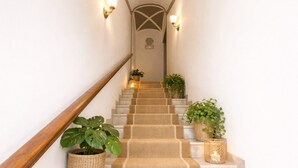 Eine Treppe mit Holzwandhandlauf, Teppichstufen und Wandleuchten.