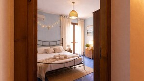 A bedroom with a bed, bedside table, lamp, and a hanging light fixture. - Visitsicilia Le Magnolie 4 (Castellammare del Golfo)