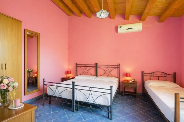 Un dormitorio con cama, mesitas de noche, un espejo, un armario y un ventilador de techo.
