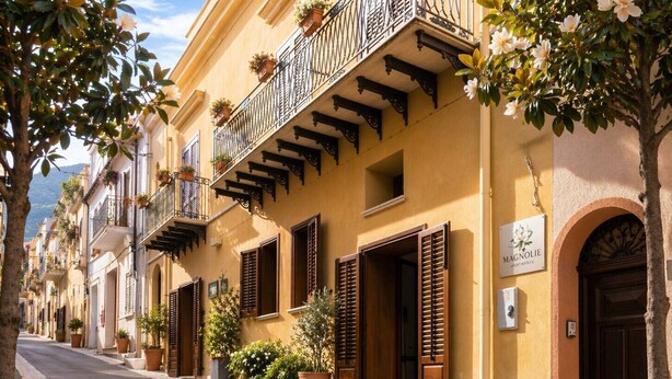 Una calle con edificios amarillos, contraventanas de madera y balcones con macetas.