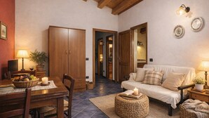 Una habitación acogedora con una mesa de comedor, armarios de madera, un sofá y una pequeña alfombra.