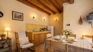 A cozy kitchen with wooden cabinets, a tiled backsplash, and a dining area with a table set for two. - Visitsicilia 6 Le Magnole 6 (Castellammare del Golfo)