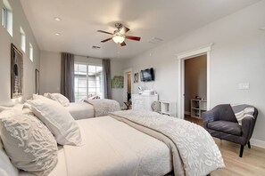 A bedroom with two beds, a ceiling fan, a TV, and a chair. - Arcadia Bright and Cheery House (Phoenix)