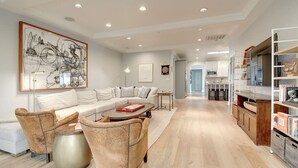 A modern living room with a sofa, armchairs, a coffee table, and a bookshelf. - Arcadia Bright and Cheery House (Phoenix)