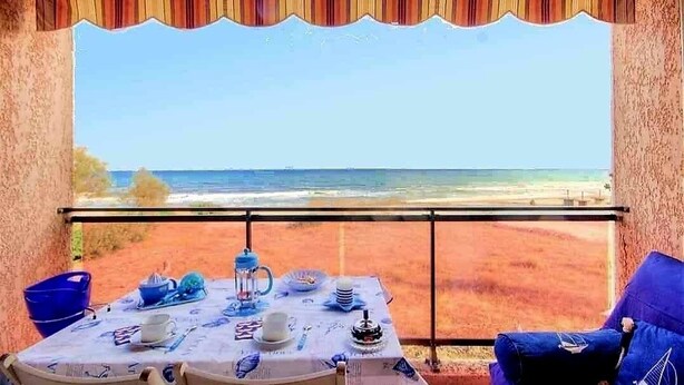 Ein Tisch mit Geschirr und Blick auf den Strand.