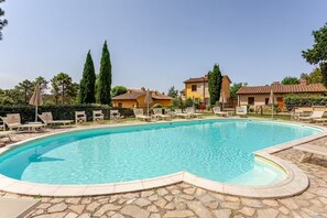 A swimming pool with lounge chairs and a stone patio. - Romantic Tuscan Cottage with Pool and Garden (Toscana)