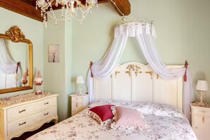 A bedroom with a canopy bed, a large mirror, a dresser, and a chandelier. - Romantic Tuscan Cottage with Pool and Garden (Toscana)