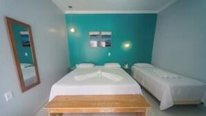 A hotel room with a large bed, a smaller bed, a wooden bench, and a wall-mounted mirror. - Pousada Vila de Charme (Barreirinhas)