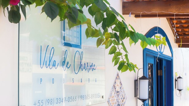 A glass sign with the name "Villa de Charme" and contact information. - Pousada Vila de Charme (Barreirinhas)