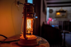 Une lanterne de style ancien posée sur une table dans une pièce à la lumière tamisée.