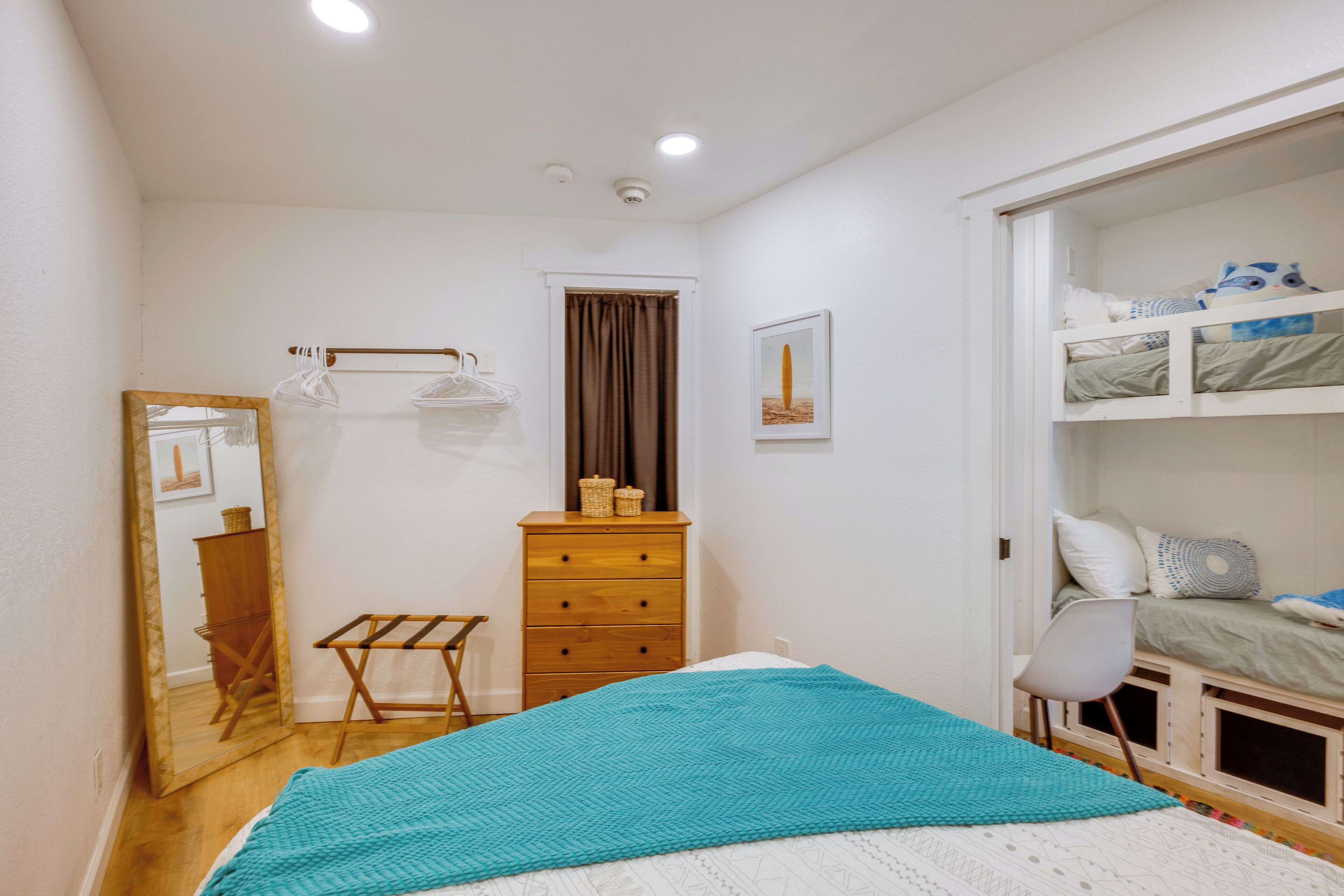 Un dormitorio con cama, cómoda, espejo, silla y armario.