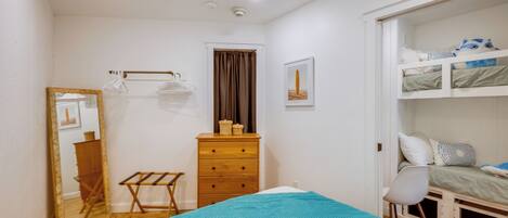 Un dormitorio con cama, cómoda, espejo, silla y armario.