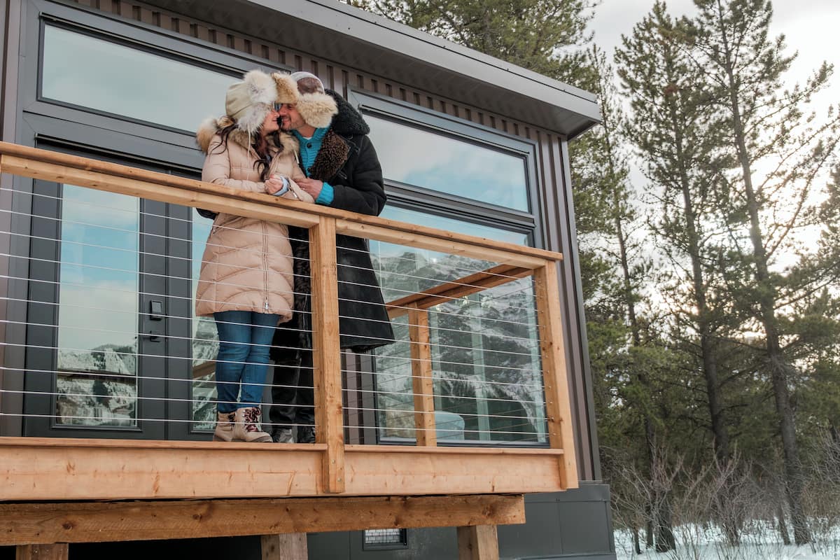 Ein Holzbalkon mit Glasveranda, der auf eine verschneite Landschaft blickt.