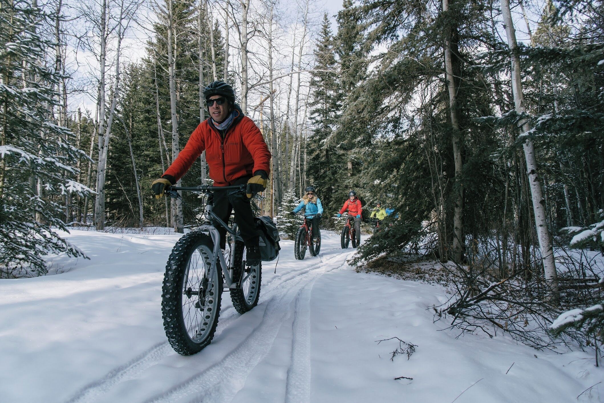 A snow-covered path with cyclists.