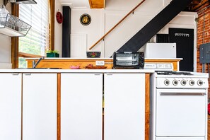 A kitchen with a white stove, a toaster, and a wooden countertop.