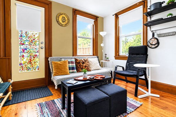 Un salon confortable avec un canapé, un fauteuil, une table basse et une petite table d’appoint.