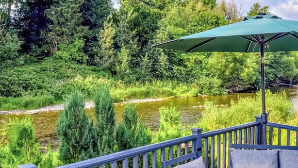 A deck with a view of a river, surrounded by greenery. - 3 bedroom accommodation in Hawick (Hawick)