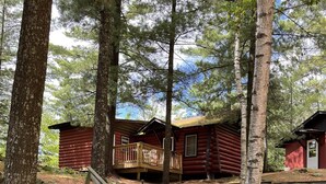 A wooden staircase leading to a cabin with a deck, surrounded by trees and rocks. - Shady Rest Cabin #4, Sunset Views, Sandy Beach, Fishing, Trails, Firepit (Rhinelanderi)