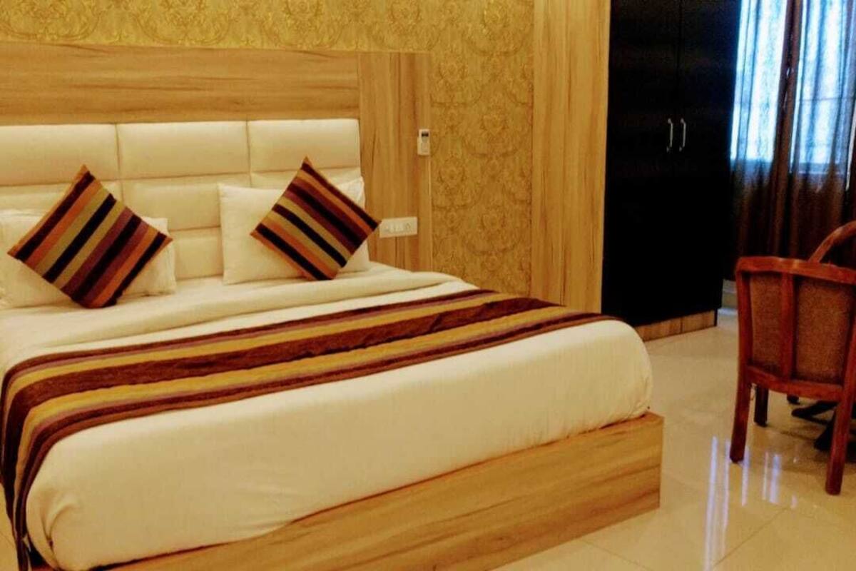 A large bed with a wooden headboard, two striped pillows, and a striped blanket.