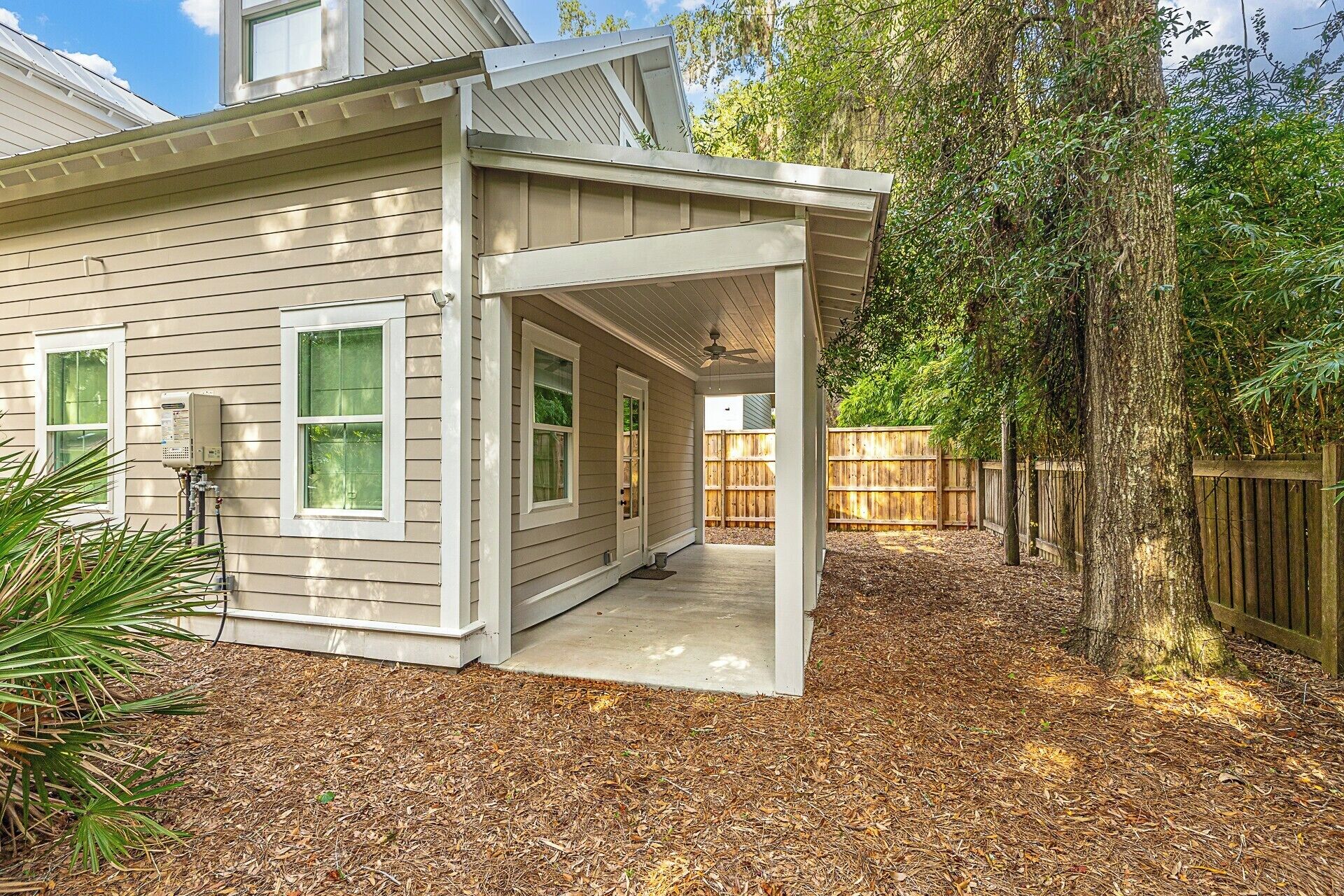 A single-story house with a covered patio, a water heater, and a wooden fence.