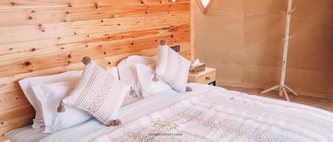 Un dormitorio con paneles de madera, una cama, almohadas y una mesita de noche.