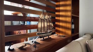 Een houten displayplank met een model schip, een fles en modelvliegtuigen.