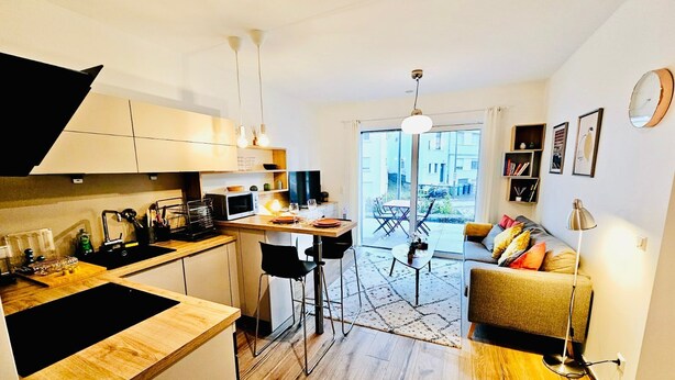 Un appartement de taille réduite comprenant une cuisine, un coin repas et un salon.