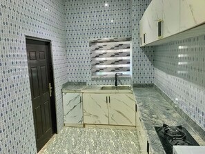 Een microgolfoven, een kookplaat, kookgerei, borden en bestek, kruiden