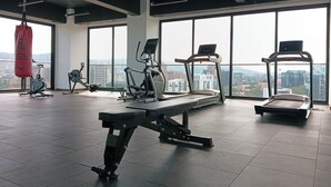 A gym with various exercise equipment, large windows, and a city view. - Luxury Apartment - Rooftop Pool in Zone 10 High Rise (Ciudad de Guatemala)