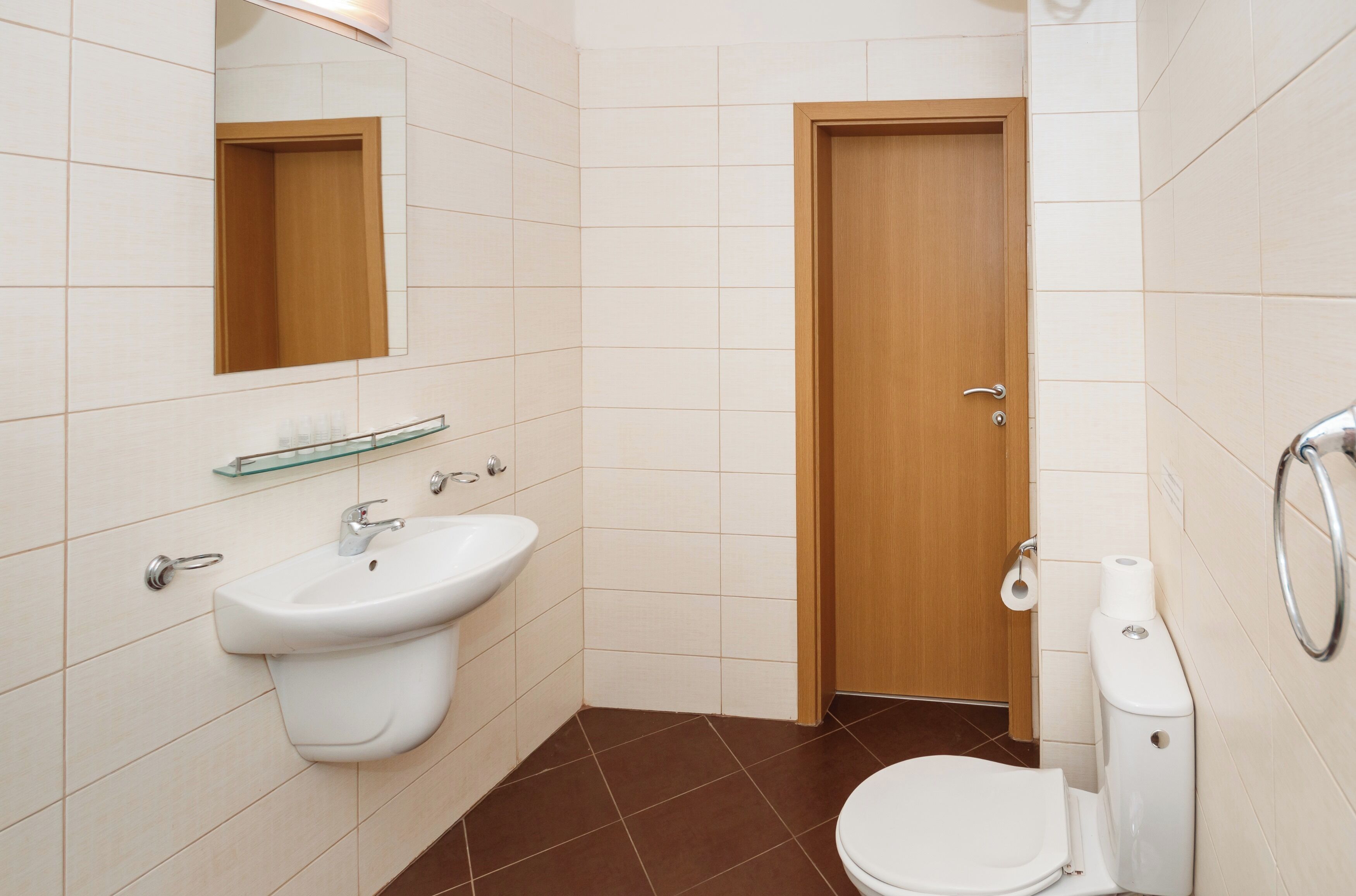 Un baño con lavamanos, inodoro y espejo.