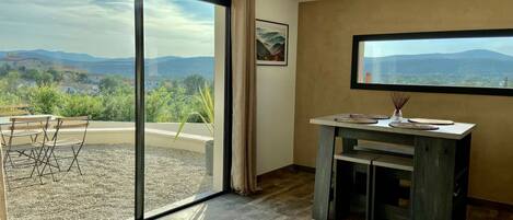 A room with a large sliding glass door leading to an outdoor area with a table and chairs.