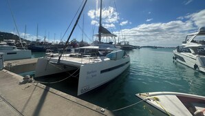 Un puerto deportivo con varios yates amarrados, incluyendo uno llamado 'Barbara Jane'.