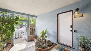 A well-maintained entrance with a door, a small garden area, and a welcome mat. - Garden Sanctuary • Fire Pit • Kitchen & Privacy (San Jose)