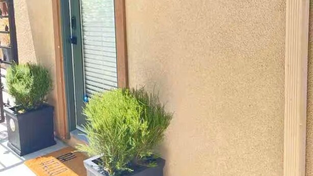 A building entrance with a door, two potted plants, and a doormat. - Serenity by the Lake. Beautiful neighborhood I short walk to lake and trails (Chula Vista)