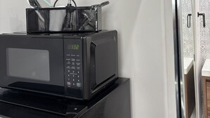 A kitchen with a microwave, a toaster, and a wine bottle on a shelf. - Serenity by the Lake. Beautiful neighborhood I short walk to lake and trails (Chula Vista)