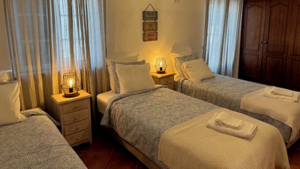 Ein Hotelzimmer mit zwei Betten, einem Holzschrank und einem an der Wand befestigten Schild.