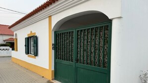 Ein Gebäude mit einem grünen Tor, gelbem Zierdekor und einem Ziegeldach.