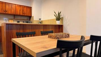 Une cuisine moderne avec des meubles en bois, un îlot central et une table à manger avec des chaises.