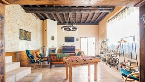 A cozy living room with a foosball table, comfortable seating, and a fireplace. - La maison de la colline (Vers)