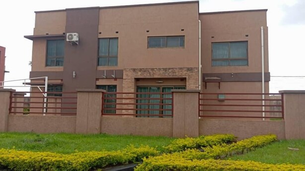 A modern two-story building with a flat roof, large windows, and a gated entrance. - New California  (Lilongwe)