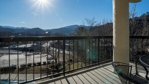 Ein Balkon mit Blick auf einen Parkplatz und Berge.