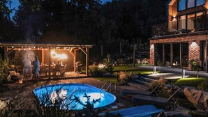 A pool area with a covered patio, a barbecue grill, and a modern house with a balcony. - Pet friendly home in Zawory with sauna (Zawory)