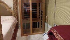 A bedroom with a bed, a wardrobe, and a window with blinds.
