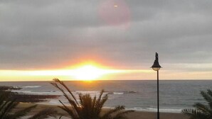 A sunset over the ocean with a street lamp in the foreground. - Dream getaway! seaview shell (Playa Honda , lanzarote)