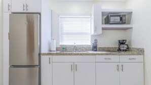 A kitchen with white cabinets, a stainless steel refrigerator, a microwave, and a coffee maker. - 4 Guest, 5 minutes from all the attractions in Miami,Airport, Downtown, Wynwood (Miami)