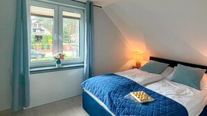 A bedroom with a bed, a window with a view of the outside, and a nightstand with a lamp. - Pet friendly home in Ostroda with WiFi (Ostroda)