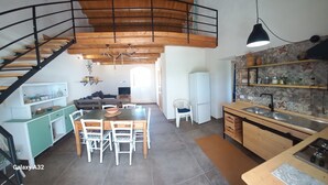 A spacious kitchen with a dining area, a staircase, and a living room.