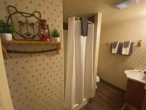 Ein Badezimmer mit Duschvorhang, Waschbecken und Handtuchhalter.